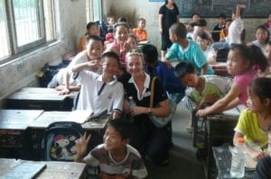 Picture of Nancy hanging with the kids at their school in China