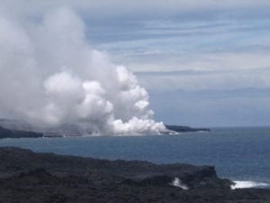 Steam rising from the sea as lava pours into it